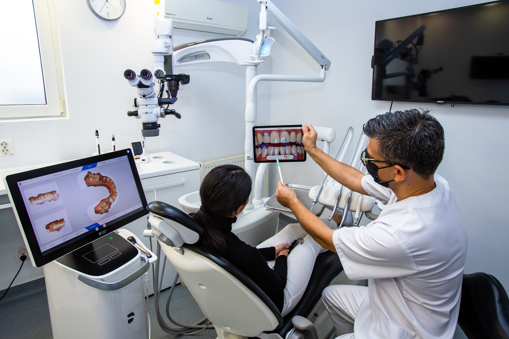 Digital Smile Design- dr. Marius Bud arata pacientului pe tableta planificarea digitala in softul Smile Cloud Asistat de AI, noul zambel planificat in cadrul clinicii Mb Dental Cluj